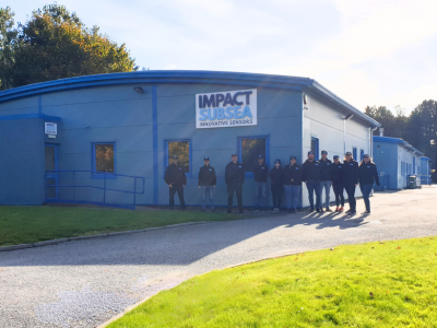 Impact Subsea team standing outside company building on a sunny day